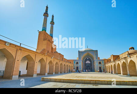 YAZD, IRAN - le 18 octobre 2017 : La grande cour de la mosquée Jameh avec arcades en brique, de chaque côté du portail central, décoré avec un carrelage et Banque D'Images