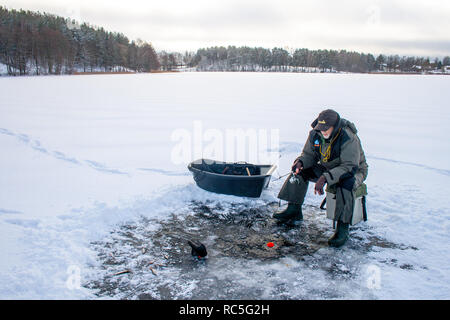 Peche sur un lac gelé en hiver, le trou et l'équipement sonar , Banque D'Images