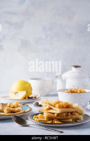 Des crêpes ou blinis servis avec du coing caramélisé. Banque D'Images