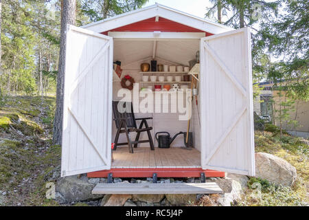 L'hangar de stockage rempli d'outils de jardin. Des pelles, des râteaux, des pots, de l'eau pitcher et tout ce dont vous avez besoin pour le jardinage. Banque D'Images