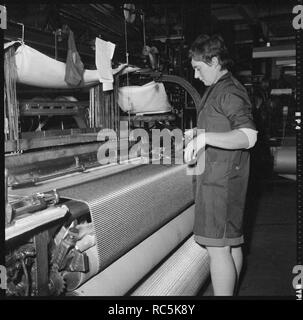 Weaver la préparation d'une navette pour l'utilisation dans un métier à tisser mécanique, 1966-1974. Organisateur : Eileen Deste. Banque D'Images