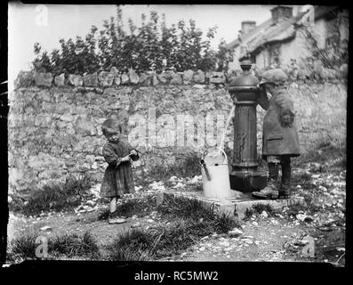 Deux enfants à la collecte de l'eau à une pompe à eau, cheddar, Somerset, 1907. Organisateur : Katherine J Macfee. Banque D'Images