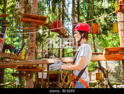 Adolescents le port du harnais de sécurité avec système d'assurage auto entrant dans l'air extérieur parcours Parcours aventure park Banque D'Images