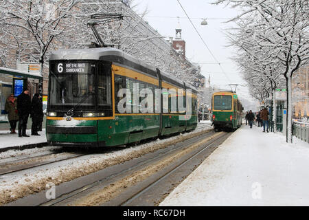 Helsinki, Finlande - 9 janvier 2019 : Les gens obtiennent sur les tramways HSL vert sur un tram dans le centre-ville d'Helsinki un jour de neige en hiver. Banque D'Images