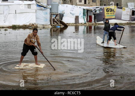 13 janvier 2019, Liban, Barelias : garçons réfugiés syriens se tenir au milieu d'eau devant leurs tentes inondées après de fortes averses à l'Barelias camp de réfugiés. Cinq jours de tempête la semaine dernière ont dévasté des milliers de camps de réfugiés syriens, et ils sont maintenant préparent à une autre grosse tempête dans les prochains jours. Photo : Marwan Naamani/afp Banque D'Images