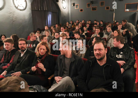 14 janvier 2019, le Schleswig-Holstein, Lübeck : Charly Hübner (avant, r-l), cinéaste et acteur, Sebastian Schultz, cinéaste, Karin Prien (CDU), Ministre de l'éducation du Schleswig-Holstein, élèves et enseignants s'asseoir à la projection du film 'Wild' dans le Kommunales Kino (KoKi). Environ 80 élèves de l'école primaire et global Timmendorfer Strand a vu le documentaire "Wildes Herz' le lundi, qui montre le développement de l'allemand "punk" Fischfillet Sahne Feiner. Photo : Christian Charisius/dpa Banque D'Images