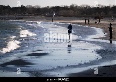 14 janvier 2019, le Schleswig-Holstein, Travemünde : les marcheurs peuvent profiter d'un soleil éclatant et des températures hivernales sur la plage de la mer Baltique dans la baie près de Lübeck Travemünde. Photo : Christian Charisius/dpa Banque D'Images