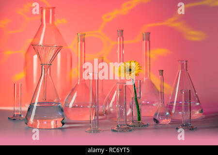 Variété de verrerie de laboratoire en partie rempli y compris le capitule dans l'ambiance rouge Banque D'Images