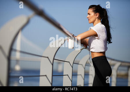 Athlète féminine pensif leaning on railing outdoors Banque D'Images
