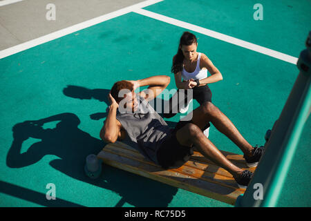 Lady coach le temps tandis que l'homme faisant des craquements Banque D'Images