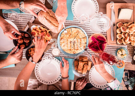 Vue de dessus de table colorés plein de culture mixte de l'alimentation et les mains et les gens de manger et s'amuser dans l'amitié ensemble - le déjeuner du Caucase doivent rejoindre célébration pour Banque D'Images