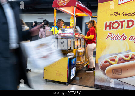 Au service de hot-dog un hot-dog à un voyageur dans un stand de hot-dog à la gare de Barcelone, ​​Spain Banque D'Images