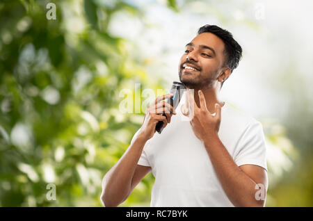 Smiling indian man rasage Tondeuse barbe avec Banque D'Images
