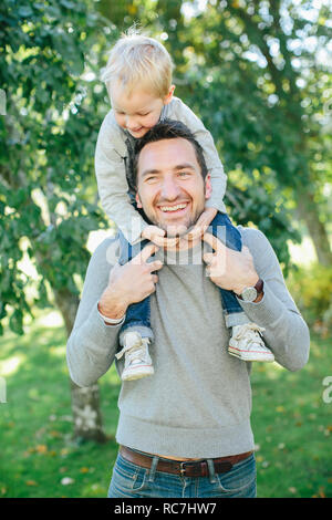 Father carrying son piggyback Banque D'Images