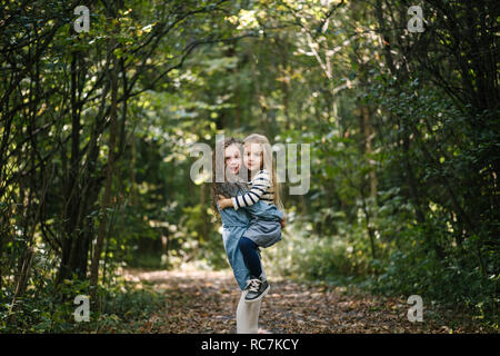 Sisters hugging in forest Banque D'Images