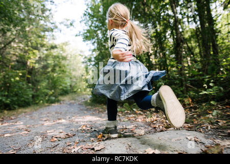 Petite fille courir en forêt Banque D'Images