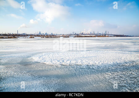 L'usine métallurgique de fumée, vu de la rive d'un lac gelé. L'usine d'acier avec smog sur journée d'hiver. Problèmes de l'écologie, la pollution atmosphérique. Banque D'Images