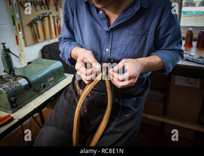 Leatherworker en cuir couture atelier, mid section Banque D'Images