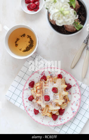 Petit-déjeuner avec télévision jeter des gaufres fraîches et des framboises sur la table Banque D'Images