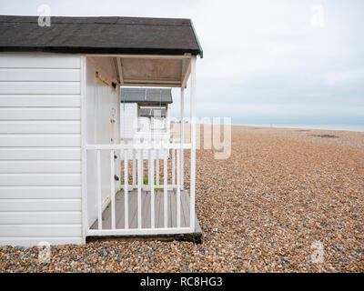 Cabines de plage blanc sur la plage de galets à Bexhill on Sea East Sussex, Royaume-Uni sur une journée d'hiver terne couvert hors de saison. Banque D'Images