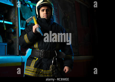 Photo d'un homme pompier avec prise près de fire truck Banque D'Images