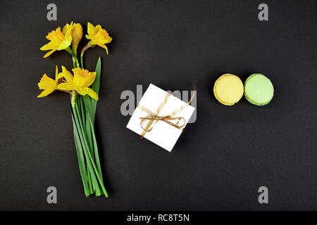 Bouquet cadeau fleurs narcisse et de douceurs et gâteaux de macarons. Bonjour. Femme ou mère Journée.concept d'accueil Banque D'Images