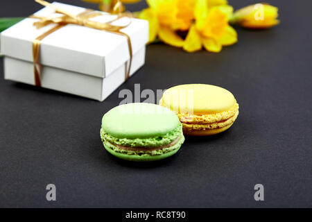 Bouquet cadeau fleurs narcisse et de douceurs et gâteaux de macarons. Bonjour. Femme ou mère Journée.concept d'accueil Banque D'Images