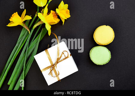 Bouquet cadeau fleurs narcisse et de douceurs et gâteaux de macarons. Bonjour. Femme ou mère Journée.concept d'accueil Banque D'Images