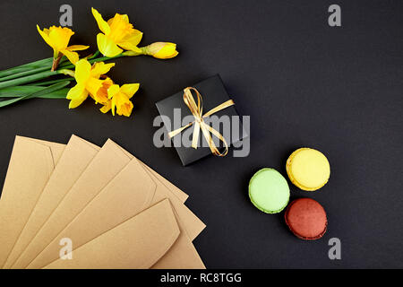 Bouquet cadeau fleurs narcisse et de douceurs et gâteaux de macarons. Bonjour. Femme ou mère Journée.concept d'accueil Banque D'Images