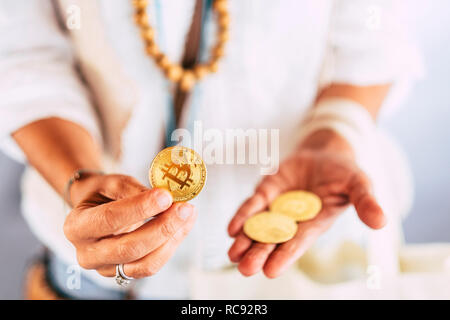 Femme d'âge moyen et l'utilisation des mains d'or pièce de monnaie bitcoin pour montrer de nouvelles technologie moderne argent virtuel cryptocurrency - concept commercial Commerce Business Daily Banque D'Images