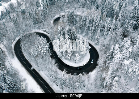 La conduite sur les routes d'hiver à travers une forêt route sinueuse dans les montagnes Banque D'Images