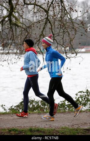 Deux jeunes femmes jogging en hiver, portant des vêtements de performance imperméable et coupe-vent Banque D'Images