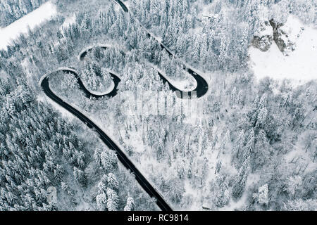 Neige dans les montagnes et route sinueuse avec des voitures Banque D'Images