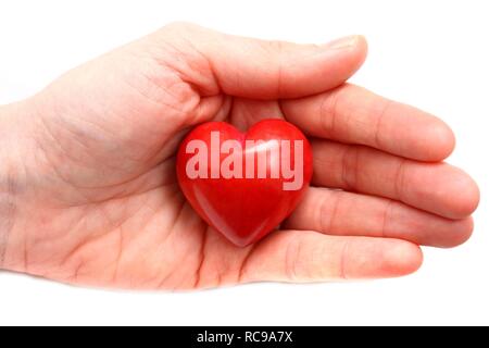 Main tenant un cœur rouge, image symbolique de la maladie cardiaque, crise cardiaque, un coeur malade, Cardiologie Banque D'Images