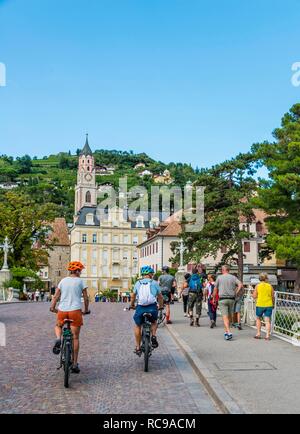 Deux cyclistes, passer Promenade, Bolzano, la porte Porta di Bolzano, église paroissiale Saint Nicolas, église de San Nicolò Banque D'Images