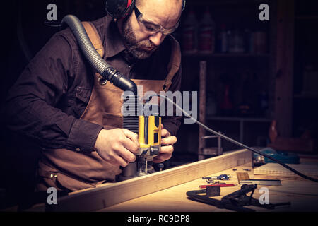 Portrait de Carpenter à l'aide d'un routeur verticale Banque D'Images