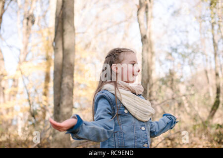 Little girl holding hands out in forest Banque D'Images