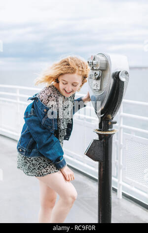 Jeune femme par jumelles à monnayeur sur pier, Menemsha, Martha's Vineyard, Massachusetts, USA Banque D'Images