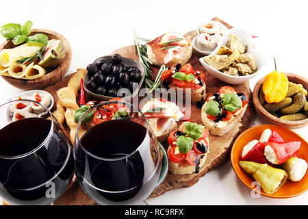 Vin antipasti italiens des en-cas. Variété de fromage, olives, cornichons Méditerranée, Prosciutto di Parma, les tomates, les artichauts et le vin dans les verres sur l'onglet Banque D'Images
