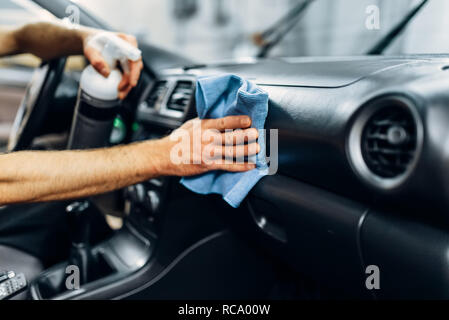 L'intérieur de la voiture automobile détaillant sur carwash service. Travailleur en beauté avec nettoyage gants Spray de polissage Banque D'Images