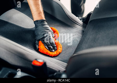 Nettoyage chimique professionnel des sièges de voiture avec spoonge. Service de lavage, travailleur masculin dans les gants à l'aide de l'agent spécial Banque D'Images