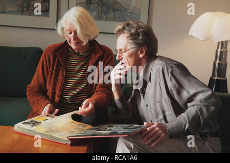 Pärchen mittleren modifie schaut sich Fotoalbum | un couple d'âge moyen est à la recherche à l'album photo Banque D'Images