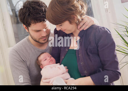 Junge Die Eltern halten ihre Tochter neugeborene im Arm, das ist genre 12 Tage alt | jeunes parents tenant son bébé nouveau-né dans ses bras - le bébé 12 ist Banque D'Images