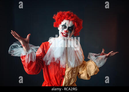 Portrait de scary clown sanglant avec un défaut. Avec l'homme en costume maquillage carnaval, mad maniac Banque D'Images