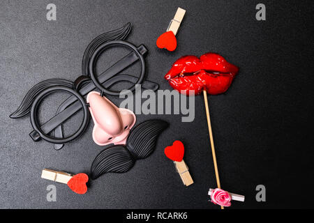 Vue de dessus de l'image drôle photo booth props pour partie ou d'un mariage sur fond noir, hommes et femmes concept, 14 février Banque D'Images