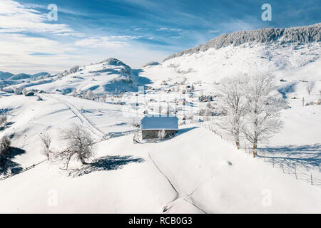 Maisons paysannes traditionnelles couvertes de neige après une forte chute de neige dans les montagnes des Carpates Banque D'Images