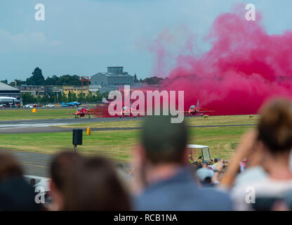 Regarder la foule des flèches rouges comme ils décollent pour démarrer leur affichage au Farnborough Airshow Farnborough, Hampshire, England, UK, Banque D'Images
