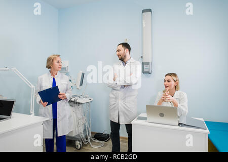 Petit groupe de médecins qui travaillent ensemble dans le cabinet du médecin. Banque D'Images