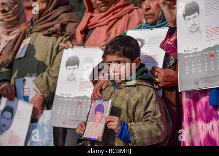 15 janvier 2019 - Srinagar, Jammu & Kashmir, Inde - un garçon du Cachemire vu la tenue d'une photographie d'une personne disparue au cours d'une manifestation exigeant sort de leurs proches dans la région de Srinagar.Pour garder la recherche de personnes disparues en vie, l'Association des Parents de personnes disparues (APDP) calendrier 2019 des rejets au cours d'une manifestation à Srinagar. L'agenda documents les histoires de disparitions, avec chaque mois de l'exercice page une photo d'une personne qui a disparu au cours de ce mois. Le calendrier propose également de nombreux poètes poésie révolutionnaire. Selon APDP Cachemiris sont plus de 8000 Banque D'Images