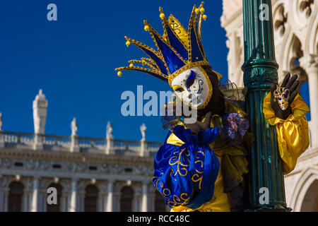 Carnaval de Venise. Un beau masque de Venise avec jester cap devant le Palais des Doges Banque D'Images